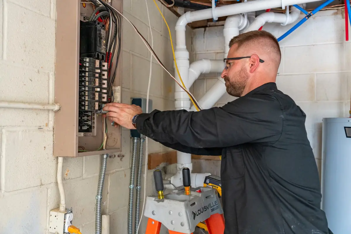 Tim Sky working at a surface-mounted panel on a commercial job